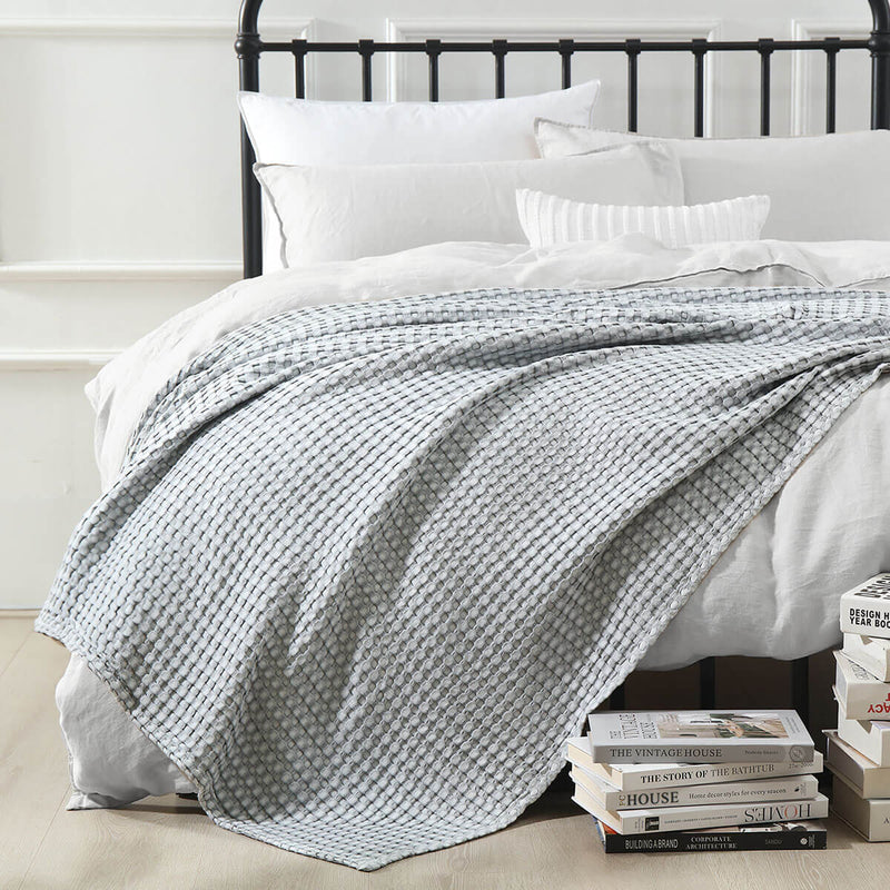 Temperature-regulating Cozy Bamboo Waffle Weave Throw Blanket in modern gray color used for layering on bed over duvet covers for a soft and cozy space relaxing and sleeping. Suitable for use on beds, couches and sofas for year-round comfort.