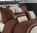 Brown and white bedding set with decorative patterns on a bed.
